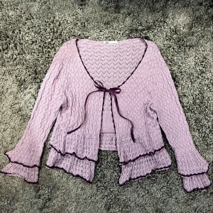 söt lila kofta 💜 - jätte söt lila kofta som jag tyvärr måste sälja då den är för liten 🥲 den har gulliga volanger och en rosett som knyts framme 💜kostade från början 250kr