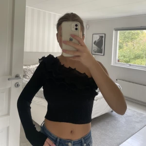 Topp med volang. - Svart topp med volang och en ärm från Zara i storlek S.