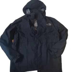 The North Face windbreaker svart - En vanlig svart windbreaker från The North Face. Det går att ta av luvan och sötta tillbaka den. Storlek L. Väldigt gott skick. Dm för frågor och intresse. Läs min bio