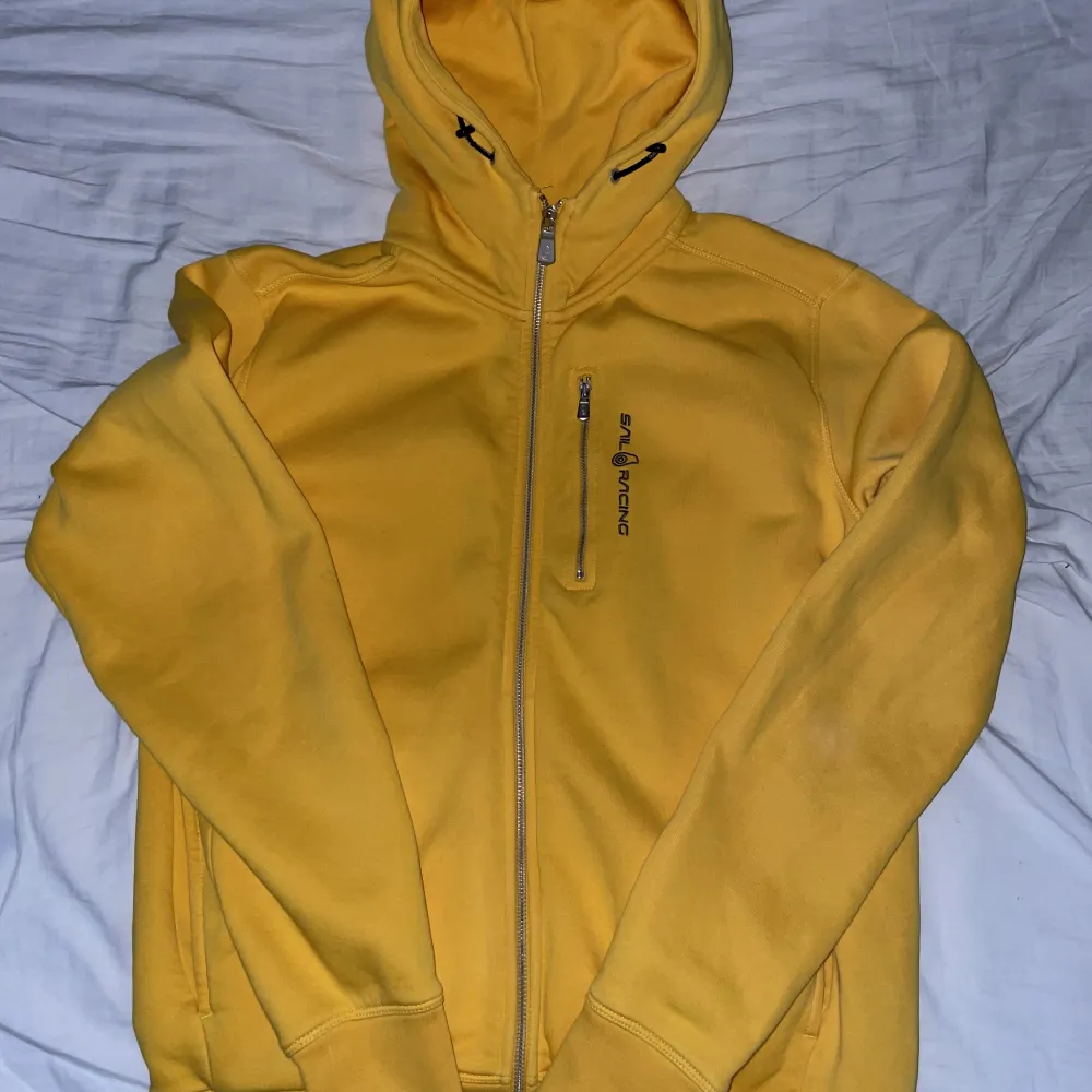 En gul sailracing zip hoodie 8/10 skick använd några gånger men inget trasigt med den . Hoodies.