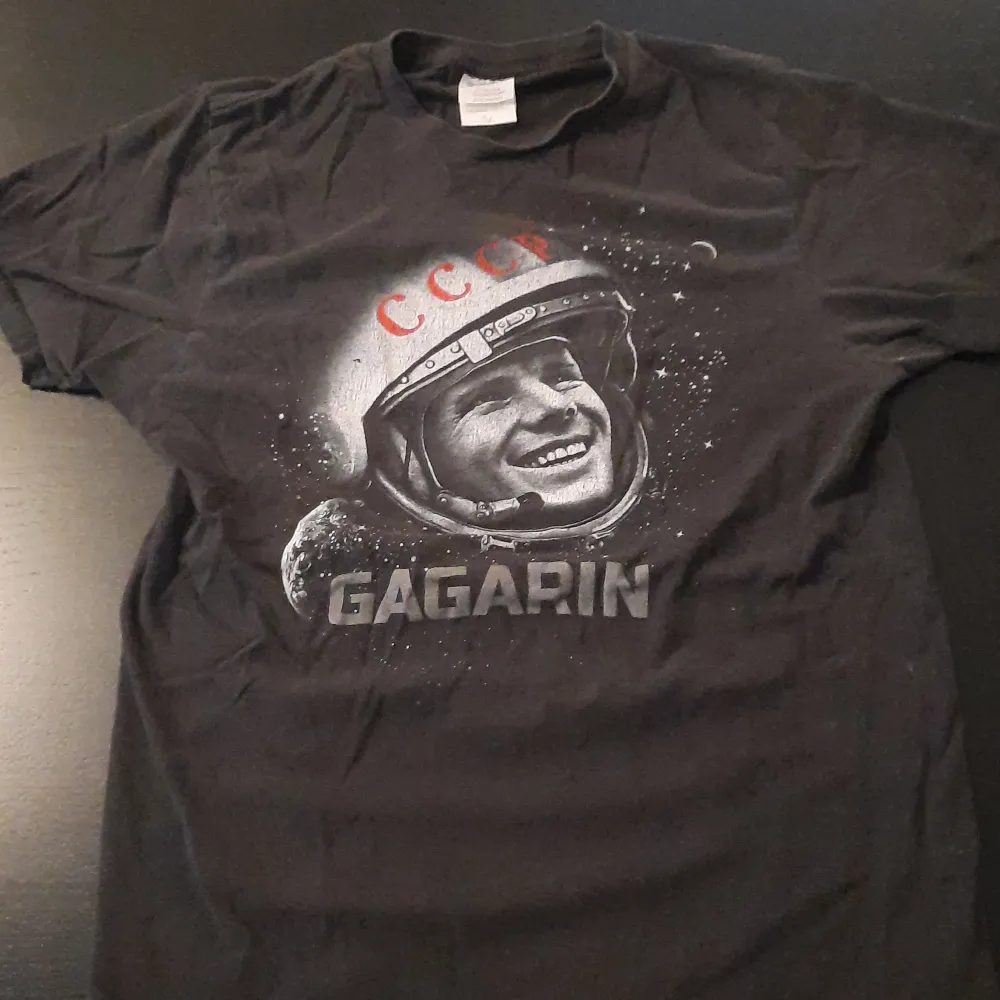 En t-shirt med tryck av en astronaut. Den är i väldigt bra skick utan hål. 100% bomull.. T-shirts.