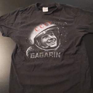 En t-shirt med tryck av en astronaut. Den är i väldigt bra skick utan hål. 100% bomull.