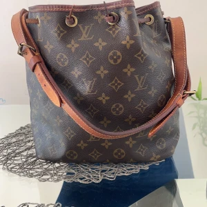 Louis Vuitton petit Noe  - Äkta och köpte flera år sedan men kvitto inte finns, väskan är ganska bra och finns några flaskor inne, kan skicka bild.