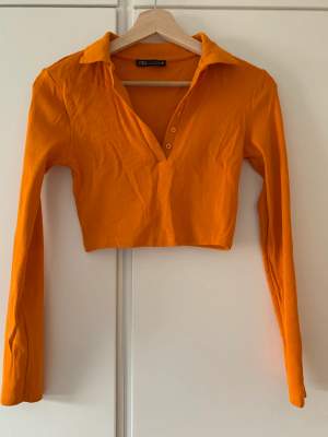 Orange långärmad crop top från Zara i orange. Endast använd en gång, i nyskick! Passar perfekt nu i höst eller till Welma kostymen.