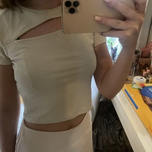 Topp - En beigh kortärmad topp med skärning över brösten. Strl S men passar även M, möjligen xs beronde på hur man vill ha den.🤍