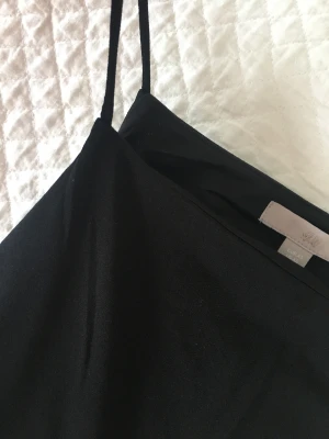 Svart linne H&m - 95% polyester  5 %elastane  40 grader tvätt. Plagget är I perfekt skick och färg och form är helt bibehållen. 