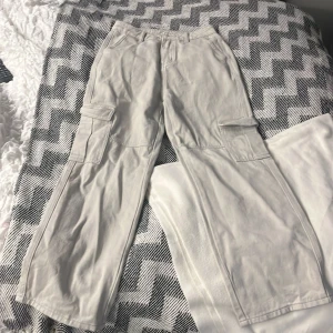 Ljus grå Cargo byxor  - En par ljus grå Cargo byxor som är mid-waist och är helt oanvänd men utan prislapp på. Dom är i väldigt bra skick. 