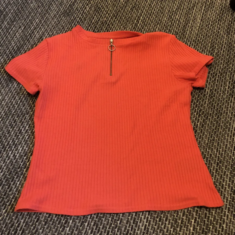 Ljusröd ribbad t-shirt från H&M i storlek M (tycker den sitter mer som en S dock). Dragkedjan går att dra ner beroende på hur man vill styla. 20kr + 30kr frakt :). T-shirts.