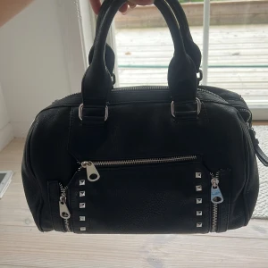 Handväska - Riktigt rymlig och snygg lite större handväska med coola nitar. Många små fack! 