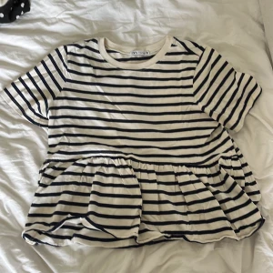T-shirt zara - Så fin tröja från zara, vit/marinblå randig med en volang! Storlek S och knappt använd! Perfekt nu till sommaren! Säljer en likadan helvit!