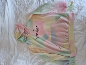 Tröja med luva - Färgglad tröja med luva och med texten Smile fram. Sparsamt använd men lite nopprig. EU 152 US 11-12Y 