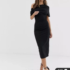 Draperad svart fodralklänningar med veck på armarna.  - Nypris 539kr, säljer för 400kr. Använt endast en gång. Storlek 34. Stilren classy klänning som framhäver kurvor fint. Kommer till under vaderna för mig som är 160cm. Fler bilder kan skickas vid önskan. Du står för frakten!