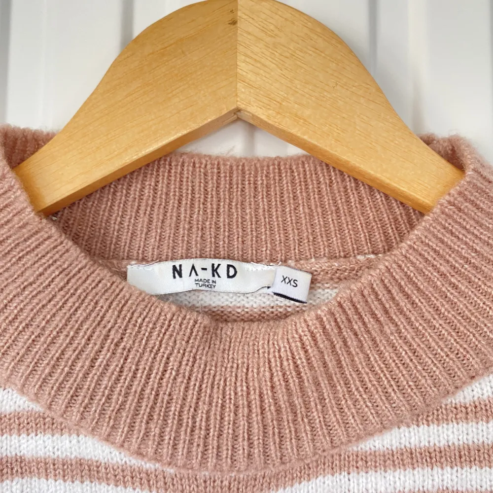 Randig stickad tröja från NA-KD i bra skick. Mid neckline, rosa och vit randig. I storlek Xss men den är oversized så funkar upp till storlek M. Stickat.