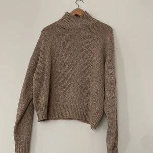 Stickad tröja - En beige stickad tröja med lägre polo. Tröjan är aldrig använd då den var för liten för mig. 