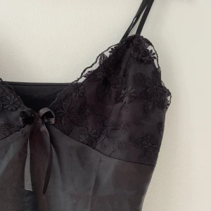 svart linne med spets - sååå fint svart vintage linne med spets och en rosett. är tyvärr lite för stor för mig </3 skulle passa xs, och en liten s! jättebra skick. hör av er ifall ni har frågor eller vill ha bilder på <3