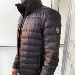 Dunjacka - Svart dunjacka i fint skick från EA7, i storlek M!  Just nu bjuder Plick på frakten!