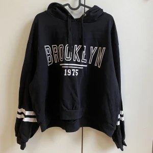 Svart hoodie  - En svart hoodie med tryck på både framsidan och armarna. Storlek XL och den är cropad men brukar ha S/M så den är som en vanlig hoodie på mig.