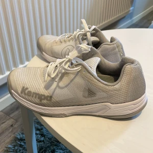 Kempa Wing 2.0 Stl. 39 - Kempa Wing 2.0 Stl. 39  Det grå tyget har fransat sig lite vid snörningen, och även ett av snörerna, annars i bra begagnat skick. 