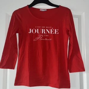 Röd trekvartslång tröja  - Röd trekvartslång tröja med text på! Perfekt basic tröja till ett par svarta Jeans. 