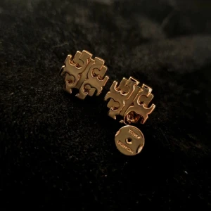 Tory Burch Logo Örhängen  - Säljer dessa stift örhängen från Tory Burch. De är I guldpläterad mässing och designade med märkets snygga och stilrena logo/ikon.  Oanvända så säljes ett pris på 599 SEK istället för nypris 1065 SEK!