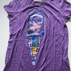 T-shirt - Lila t-shirt med tecknat tryck på framsidan 