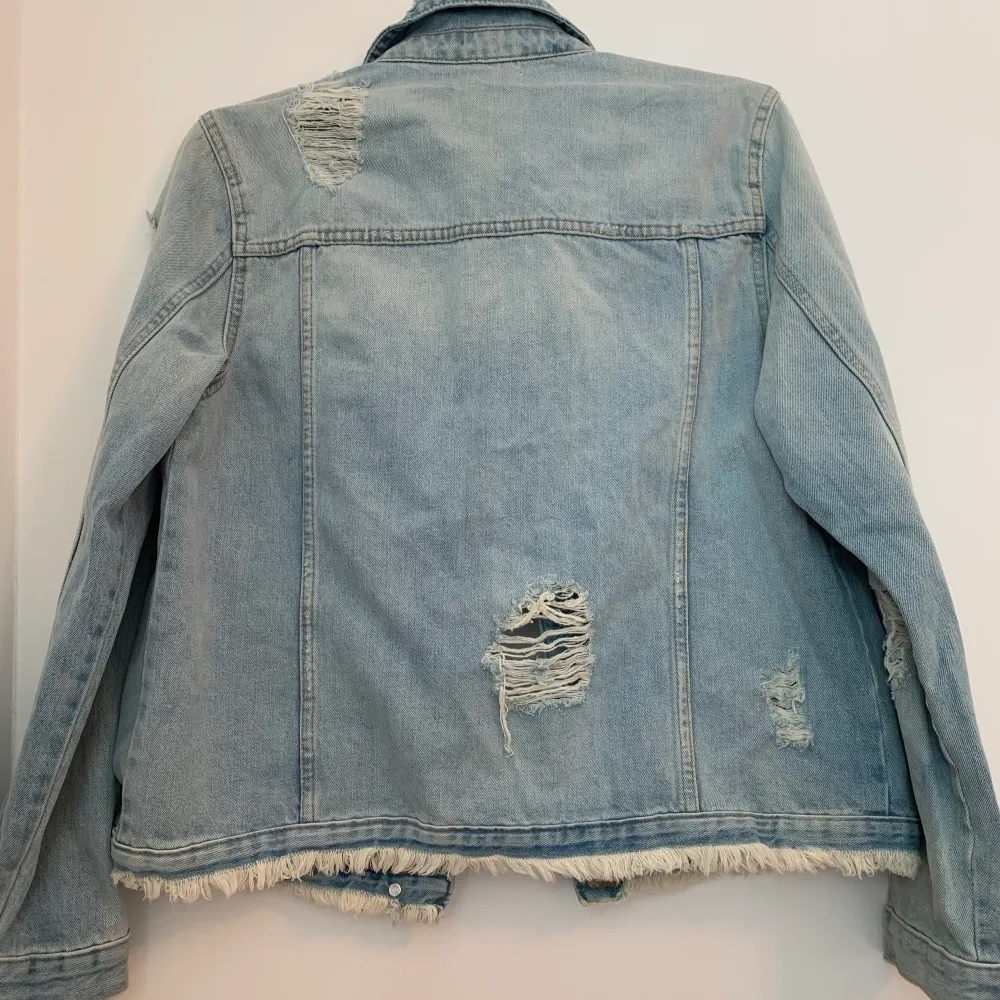 Helt ny, oanvänd, jeansjacka med prislappen kvar, från River Island i storlek 40. Jackan har en fin ljusblå färg och slitningar. Nypris ca 500kr.. Jackor.