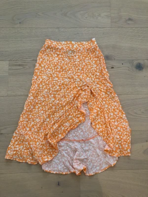 Orangeblommig kjol - Superfin blommig kjol från bershka, använt fåtal gånger.