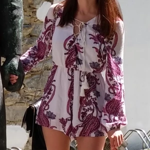 Playsuit - Somrig playsuit med snyggt mönster och snörning i fram. Ej så mycket stretch så dragkedjan är toppen, lite resår i midjan. Använd och i gott skick!