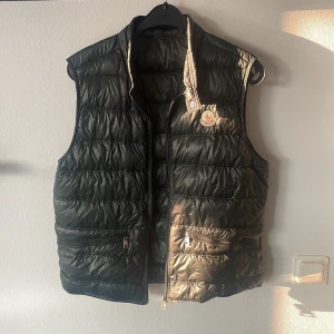 Moncler väst - Moncler väst Storlek 3 s/m Cond 7/10 Ett super litet hål på ryggen och dragkedjan är lite skadad längst nere men funkar utan problem därav så lågt pris Kvitto kastat 