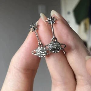 Vivienne Westwood liknande örhängen - Ett par silvriga Vivienne Westwood liknande örhängen. Endast testade.