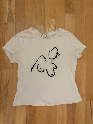 Vit t-shirt - En vit T-shirt med ett tryck av en naken kvinna. Super fin och i bra skick!