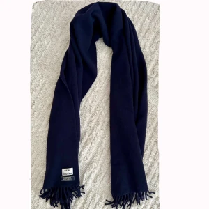 Halsduk Acne  - Mörkblå halsduk i lammull från Acne Studios. Använd endast fåtal gånger. 