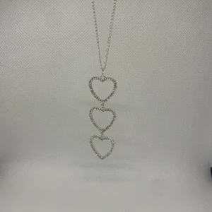 Halsband med hjärtan på - Ganska långt halsband, med tre hjärtan på. Den är silver färgad. Har slutat använda men väldigt bra skick. Det är inte äkta silver. 💥👍🏻