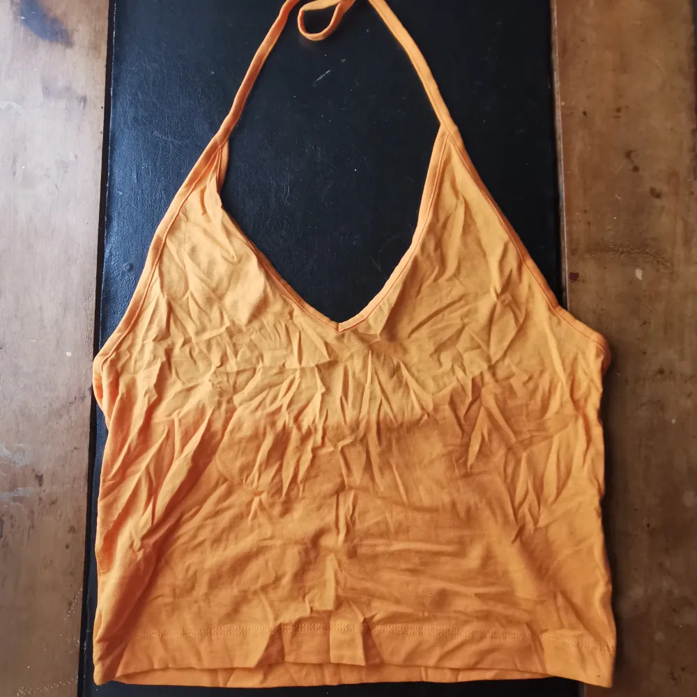 Söt orange linne i halterneck stil, köpt på secondhand. Skicka gärna meddelande om du undrar något :) ✨. Toppar.
