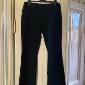 Vintage kostymbyxor - Svarta kostymbyxor köpta second hand med smala vita ränder. 