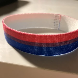 Bisexuellt arm-fotband - Bisexuella flaggan i ett arm/fotband från Happy Pride,fint skick, oanvänd  och har stretch i sig