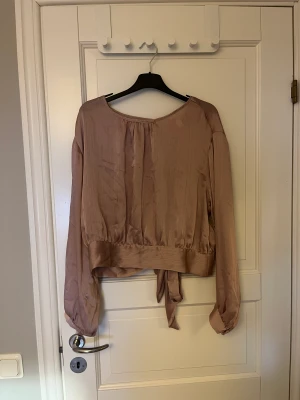 Knut blus  - Rosa blus med öppen rygg som man knyter längst ner 