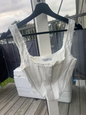 Vit crop top corset - Skit snygg. Väldigt bra skick med. Gillar verkligen inte hur den sitter på mig då jag har väldigt breda axlar.
