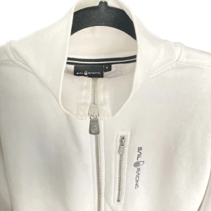 Sail Racing Zip Hood - En vit Zip Hood från välkända Sail Racing.  Använd fåtal gånger, mycket fint skick.  Storlek: S Skick: 9/10