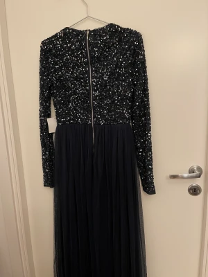 Festklänning från Maya Collection  - Marinblå långärmad maxiklänning i tyll med paljetter.