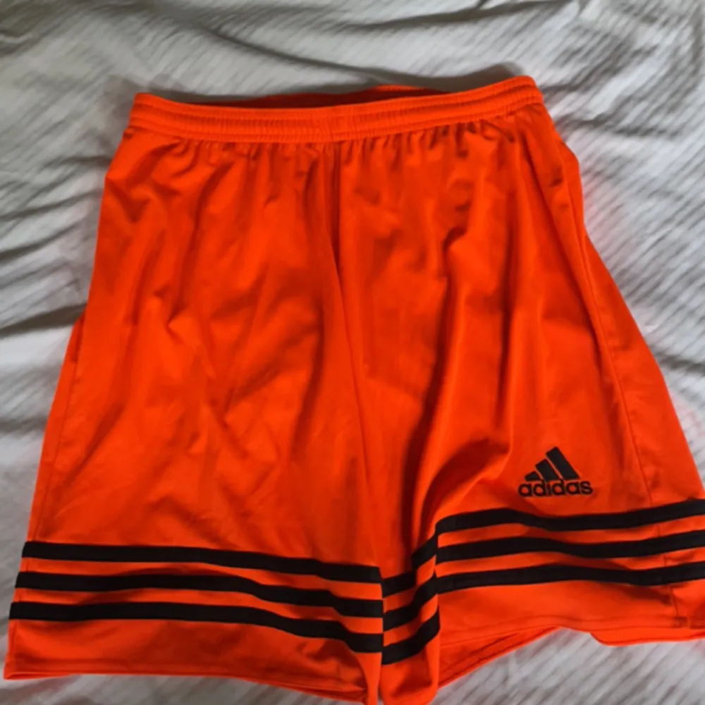 Ett par orange adidas shorts is Torkel M, aldrig använda. Köpare står för frakt!. Shorts.