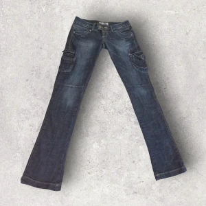 Y2K Lågmidjade jeans med flare från TRF - 2000's - Coola lågmidjade jeans från TRF i äkta Y2K-stuk, med extra fickor på sidan av benen. Flare-modell. Storlek 28. Midjemått rakt över 42cm, innerbensmått 90cm. Använd gärna köp-knappen 💖💖💖
