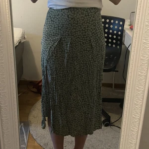 Grön blommig kjol - Grön blommig kjol från hm! Somrig och fin med två slitsar. Lite liten i storleken🫶🏼