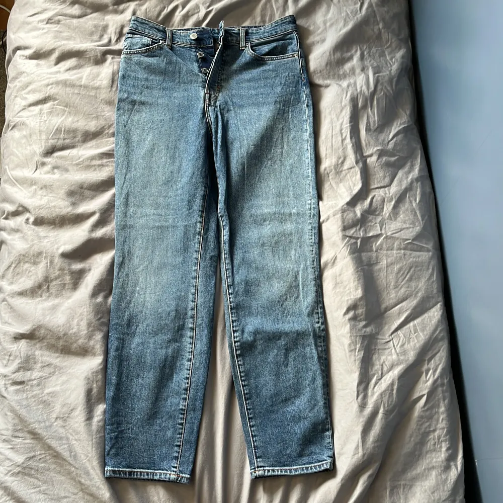 Säljer dessa snygga jeans från H&M i storlek 38 då dom inte passar längre. Känns mer som storlek 36. Passform mom jeans high waist. Färgen på jeansen syns på bild 1 och 2. Använda men i bra skick!. Jeans & Byxor.
