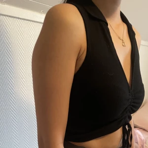 Kort top svart topp med prislapp - En svart kort ribbad topp från Zara. Säljs då jag aldrig har använt den