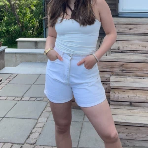 Vita denimshorts - Ett par vita denimshorts från Gina Tricot. Funkar att ha både nere eller uppvikta. Endast använda ett fåtal gånger, men har lyckats få en lite bläckfläck, men går nog bort i tvätten. Säljer för att de är för små.🤍