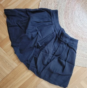 Kjol BikBok svart stl.XS - Kort svart kjol.stl XS. Flowy Skirt. Resår baktill i linningen. Ca 67cm runtom lininngen, Längd ca 37cm. Svart foder. Obetydligt använd, välvårdad.
