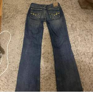 Mycket snygga & lågmidjade jeans, det är märkblå med gula sömmar. Midjemått: 72cm. Innerbenslängd: 81cm! Skriv om du har funderingar! ❤️‍🔥