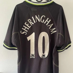 Sheringham United 98/99  - United Bortatröja 98/99 med Teddy Sheringham på ryggen.  Inga fel eller skador på den.  Tröjan är självklart äkta. Vid frågor eller om du vill ha mer bilder är det bara skriva, bilderna zoomas in med Plick så om du vill ha original bilder finns det. 