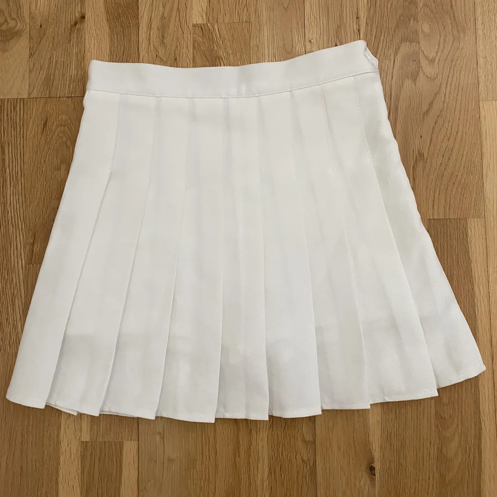 Supergullig vit veckad kjol med inbyggda shorts! Bara provad men aldrig använd. Storlek: S (dock väldigt liten storlek så skulle säga XS, ca 66cm i midjan och 38 cm lång). Kjolar.